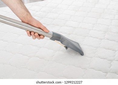 Man disinfecting mattress with vacuum cleaner, closeup. Space for text - Shutterstock ID 1299212227