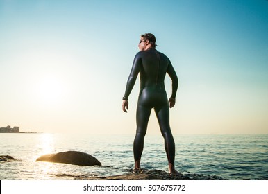 Man In Diving Suit Standing In Waves