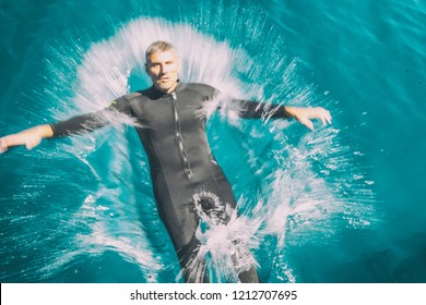 Man Diving In The Water. Ocean Spash After The Jump.