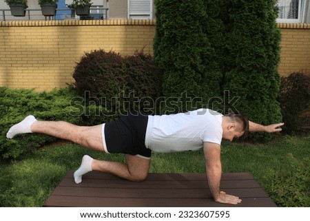 Man do back exercises for lower back Quadruped arm, leg raise