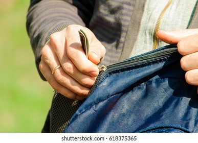 Man is docking a backpack close up in nature. 