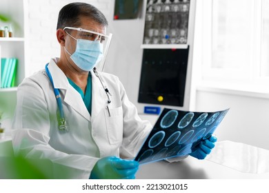 Man Doctor Examining Head Mri While Sitting At The Table In Hospital