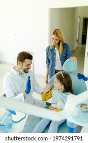 Man Doctor Is Giving Hi Five To Little Girl After A Successful Dental Examination.