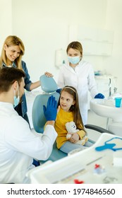 Man Doctor Is Giving Hi Five To Little Girl After A Successful Dental Examination.