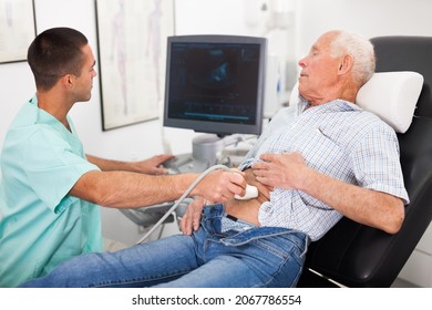 Man Doctor Pointing To Monitor During Examination A Mature Man With Ultrasound