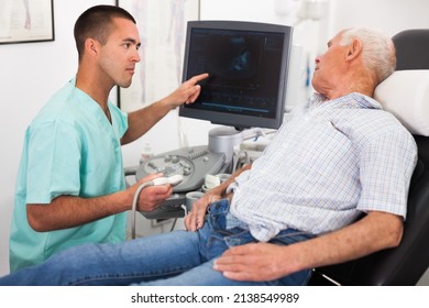 Man Doctor Pointing To Monitor During Examination A Mature Man With Ultrasound