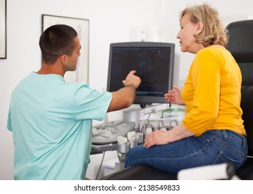 Man Doctor Pointing To Result After Examination A Mature Woman With Ultrasound