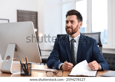 Man with document working at table in office