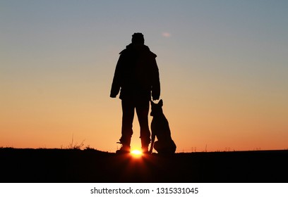 A Man And A Dog Against The Backdrop Of An Incredible Sunset