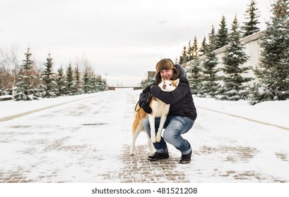 Man With Dog Of Breed Husky In Winter On The Snow