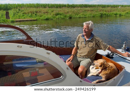 Man and dog in motor boat on the river