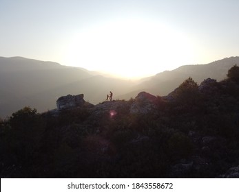 Man And Dog Silhouette Doing High Five Watching The Sunset