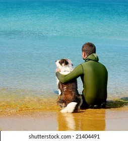 Man And Dog Sitting In The Water