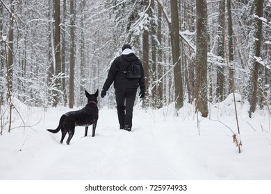 Man With A Dog In Winter Forest