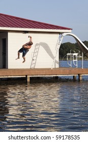 A man is doing a back flip off the end of a dock into the water