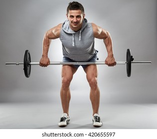 Man Doing Back Workout, Barbell Row In Studio Over Gray Background