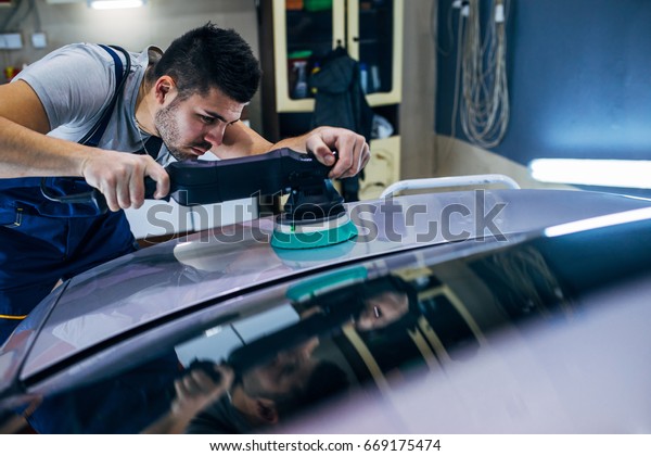 Man doing a car\
polish with the machine.