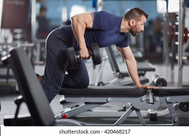 Man Doing Dumbbell Row For Back Workout In The Gym