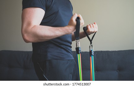 Man doing exercises with resistance bands at home. - Powered by Shutterstock