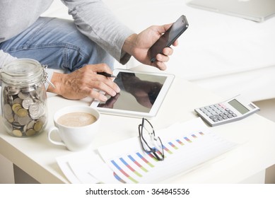 Man doing finance with tablet computer and mobile phone - Shutterstock ID 364845536