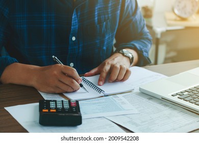Man doing finances and calculate about cost to real estate investment and in other, tax system.Time for Taxes Money Financial Accounting Taxation Concept
