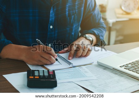 Man doing finances and calculate about cost to real estate investment and in other, tax system.Time for Taxes Money Financial Accounting Taxation Concept
