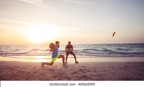 Man Doing Fitness On The Beach With The Help Of Personal Trainer. Warm Tone, Lens Flare.