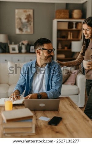 Man doing freelance work and getting distracted by beautiful wife	