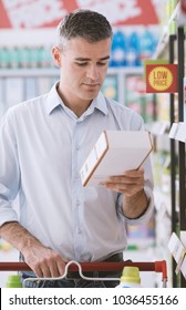 Man Doing Grocery Shopping At The Supermarket And Reading A Food Label On A Box, Shopping And Nutrition Concept