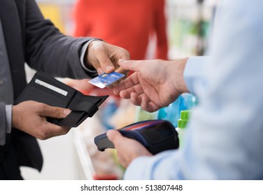 Man Doing Grocery Shopping At The Supermarket And Paying With A Credit Card At The Store Checkout