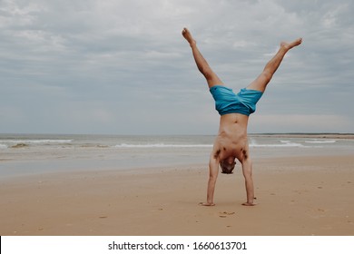 Man doing a handstand in the beach