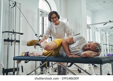 Man Doing A Lateral Leg Raise Assisted By A Doctor