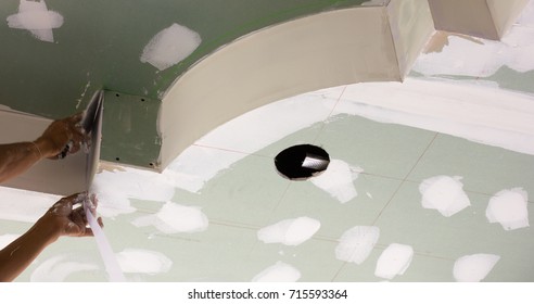A man is doing a light ceiling hole in the ceiling of the room.