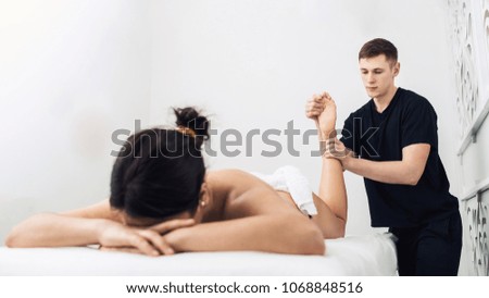 man is doing massage foot to beautiful young woman at spa. Concept of healthy lifestyle