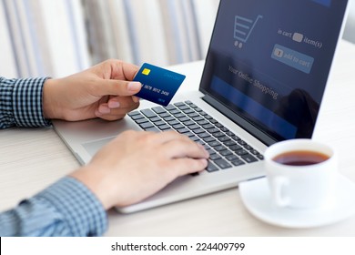 man doing online shopping with credit card on laptop