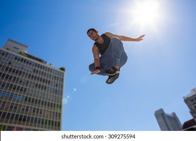 Man doing parkour in the city on a sunny day - Powered by Shutterstock