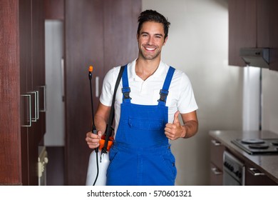 Man Doing Pest Control In Kitchen In A House