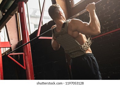 Man Doing Pull Up Exercise. Sportsman During His Workout In The Gym.