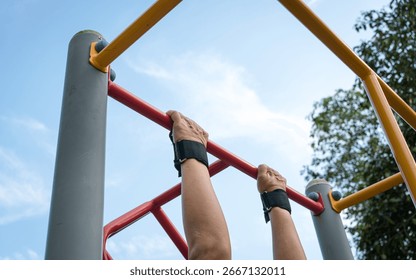 Man doing pull ups workout on the steel bar using a wrist grip. Close up view.