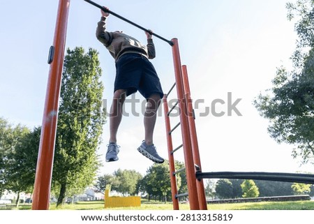 Man doing pullups on outdoor exercise bar