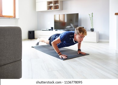 Man Doing Push Up At Home With Smartphone