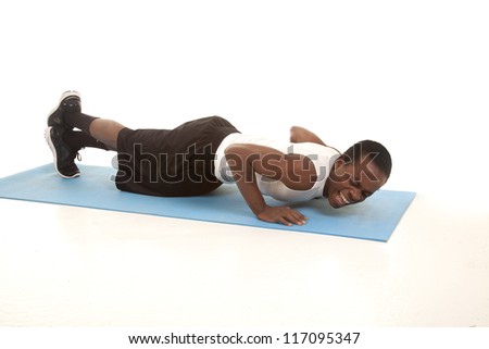 A man doing a push up with a painful expression on his face.