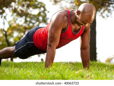 A Man Doing A Push Up In A Park