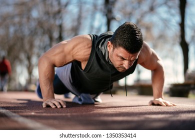 Man doing a push up. Trainer exercises outdoors.