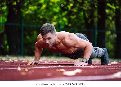 A man is doing push ups on a track