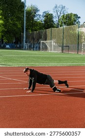Man doing push-ups on a running track