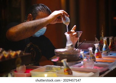 A Man Doing Sand Art On Bottle In Dubai