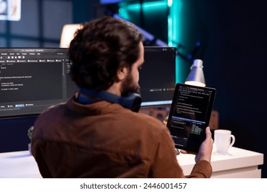 Man doing software quality assurance using tablet, reading source code before implementing it. Programmer inspecting coding on portable device, looking to fix potential bugs - Powered by Shutterstock - Get 15% off with code: PIKWIZARD15