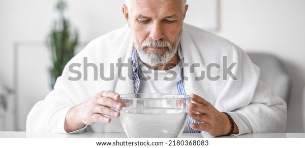 Man doing steam inhalation at home to soothe and\
open nasal passages