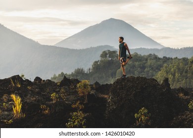 Mann, der sich ausstreckt und sich auf das Training vorbereitet und im Freien läuft. Beeindruckende Bergsicht auf dem Hintergrund. Erlebnissportkonzept.